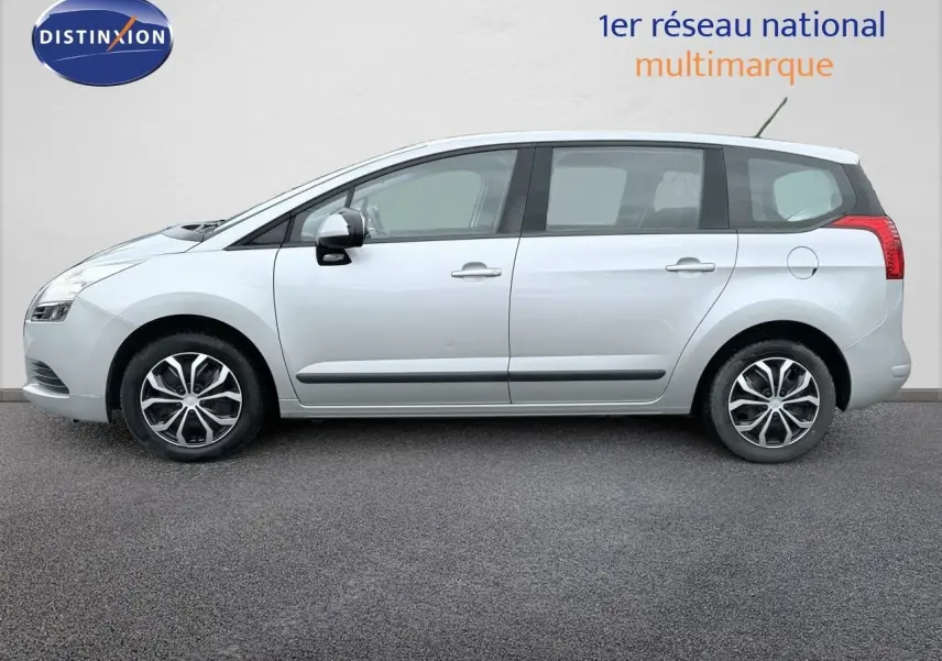 Peugeot 5008 gris en vue de profil côté gauche, montrant les jantes et les lignes latérales du véhicule.