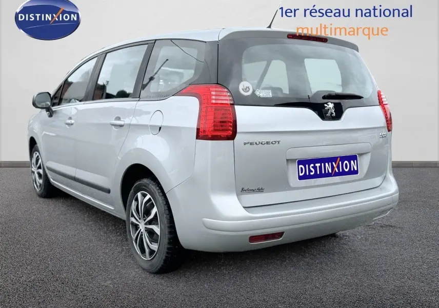 Vue 3/4 arrière droite d'un Peugeot 5008 gris avec hayon noir et feux arrière rouges.