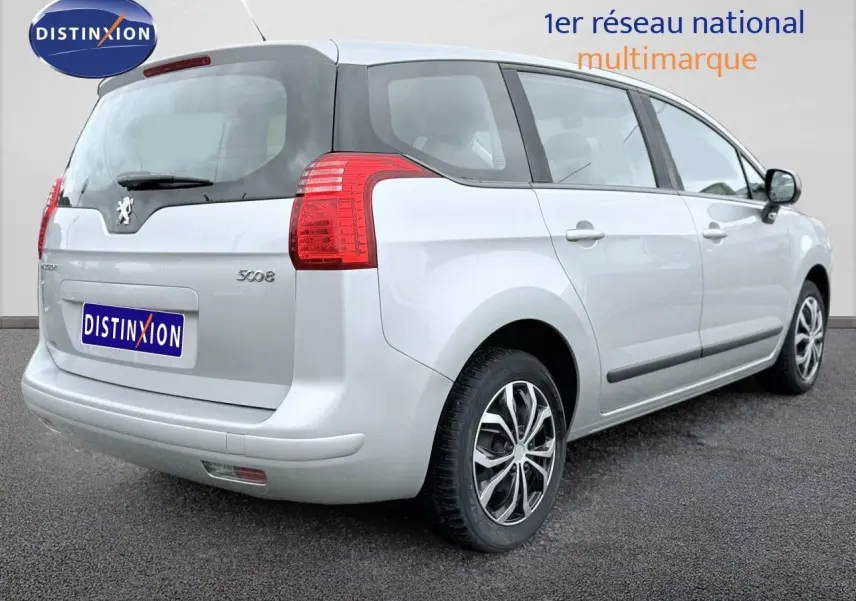 Vue 3/4 arrière droite d'un Peugeot 5008 gris 2010 avec hayon et feux arrière rouges visibles.