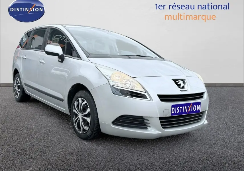 Peugeot 5008 gris vue 3/4 avant droit sur fond neutre avec jantes alliage et calandre distinctive.