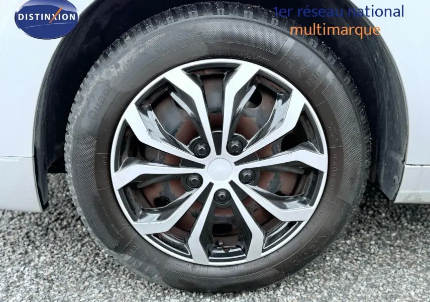 Gros plan sur la roue avant droite d’un Peugeot 5008 gris, mettant en valeur la jante alliage au design moderne.