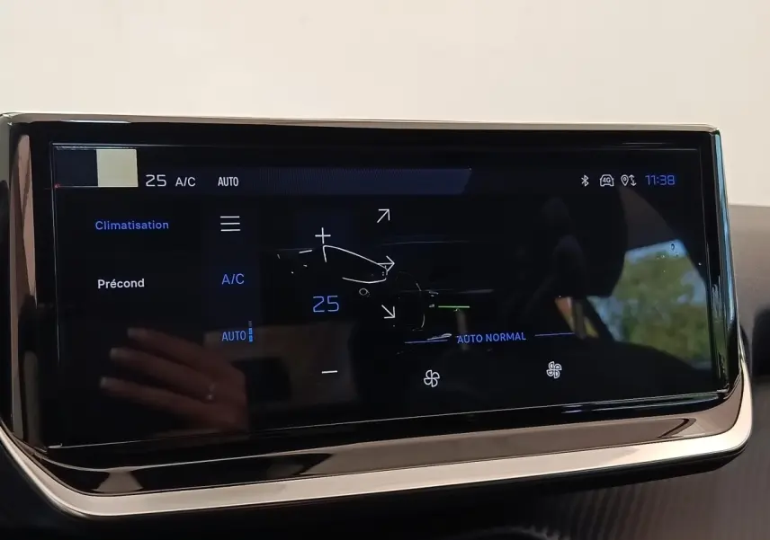 Écran tactile central affichant la climatisation automatique à 25°C dans une Peugeot 208 électrique blanche de 2024.