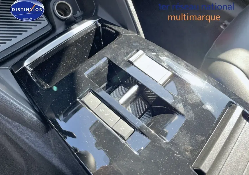 Gros plan sur la console centrale noire brillante de la Citroën C4 2024 avec commandes de boîte automatique.