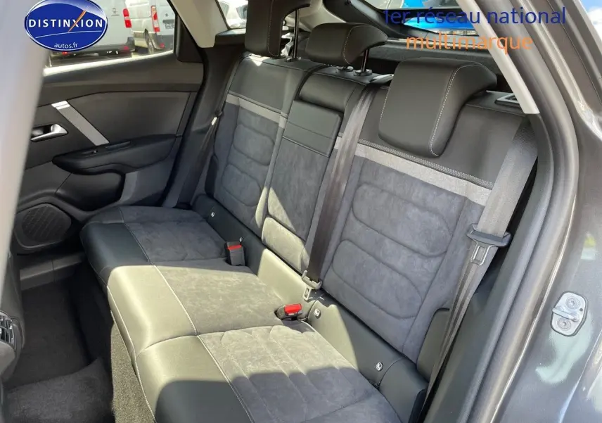 Vue intérieure arrière montrant les sièges arrière en cuir noir et tissu gris d'une Citroën C4 gris platinium 2024.