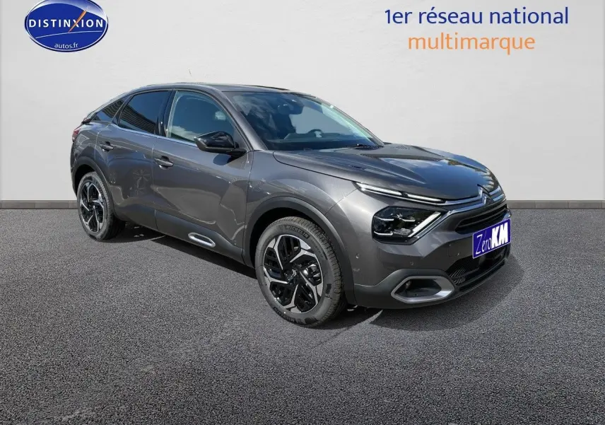 Citroën C4 gris platinium métal vue 3/4 avant droit, mettant en valeur ses lignes fluides et ses jantes noires bicolores.