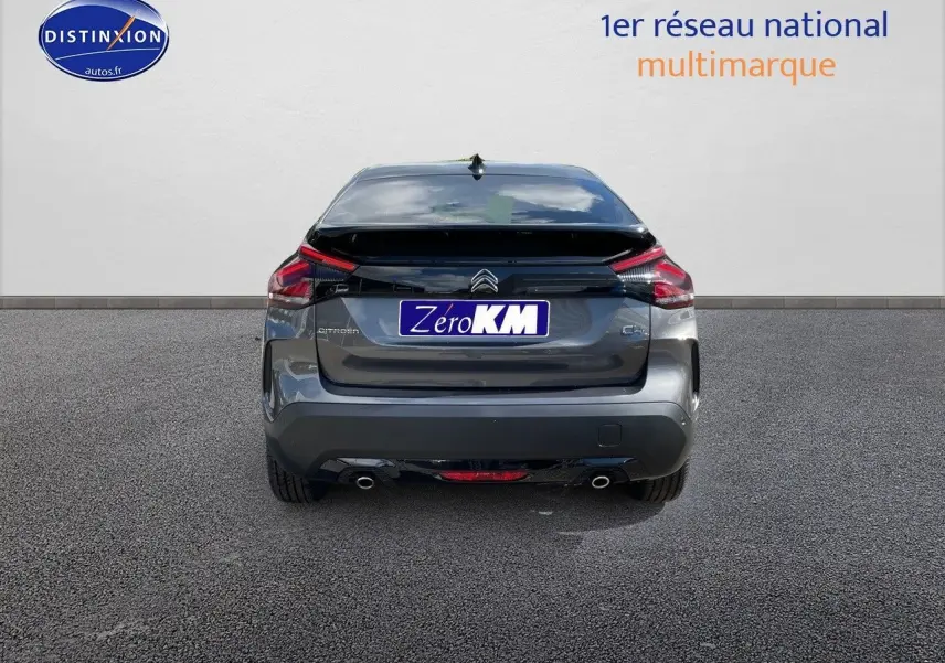 Vue arrière d'une Citroën C4 gris platinium métal 2024 avec feux LED et double sortie d'échappement visible.