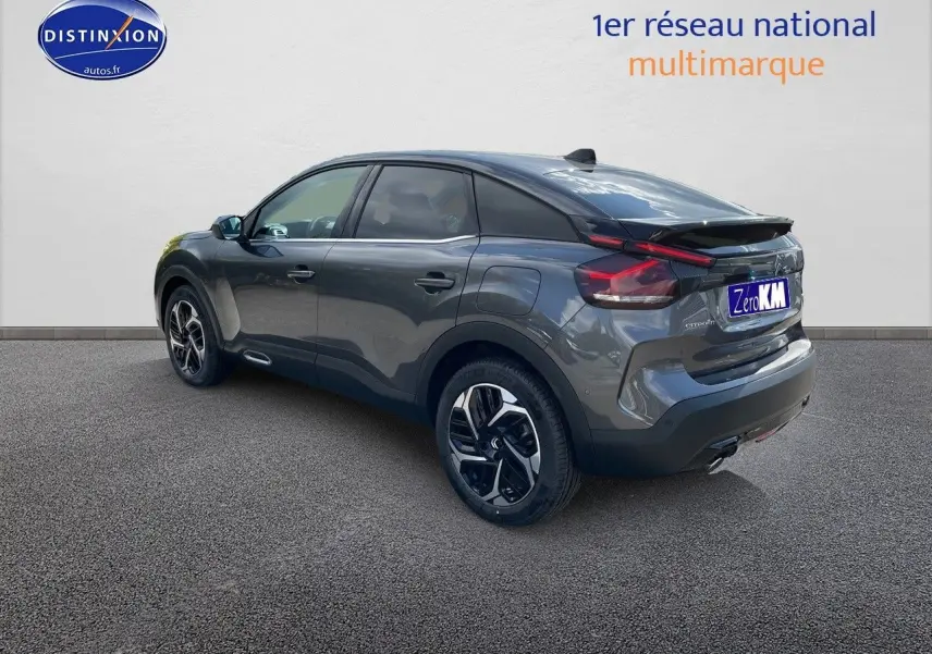 Citroën C4 gris platinium métal vue 3/4 arrière droit, mettant en valeur ses feux LED et jantes bicolores.