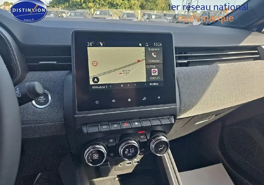 Tableau de bord de Renault Clio V bleu iron 2025, vue centrale sur écran tactile et commandes climatisation.