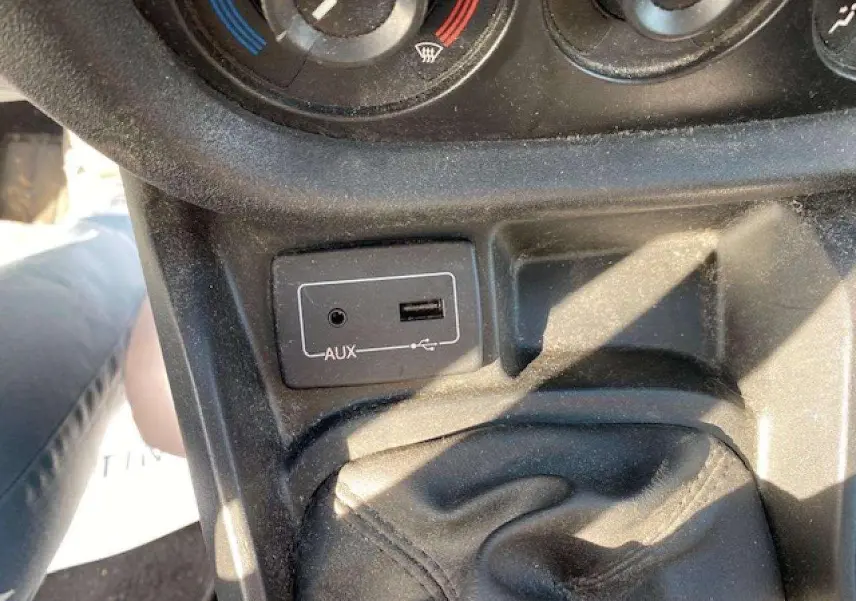 Vue rapprochée de la console centrale du Fiat Doblo 2017 montrant la prise AUX et USB près du levier de vitesses.