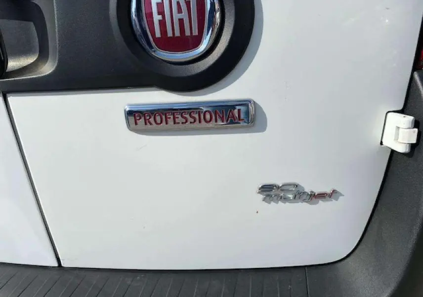 Gros plan sur la porte arrière blanche d'un FIAT Doblo 1.3 Multijet avec badges Professional et 90 Multijet.