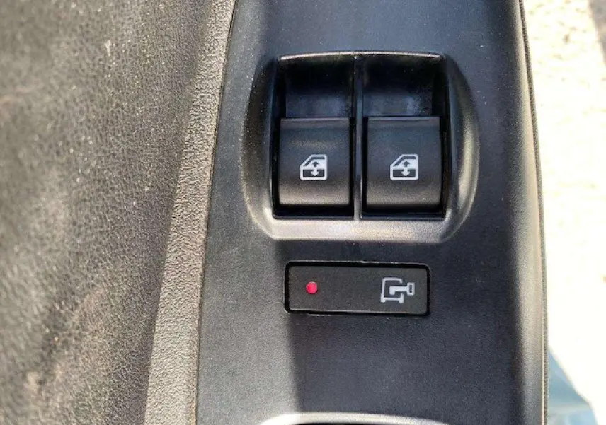 Gros plan sur les boutons de commande des vitres électriques du côté conducteur du Fiat Doblo blanc de 2017.