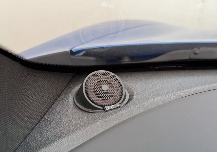 Gros plan sur le haut-parleur Focal intégré au tableau de bord d'une Alpine A110 Legende bleu, côté gauche.