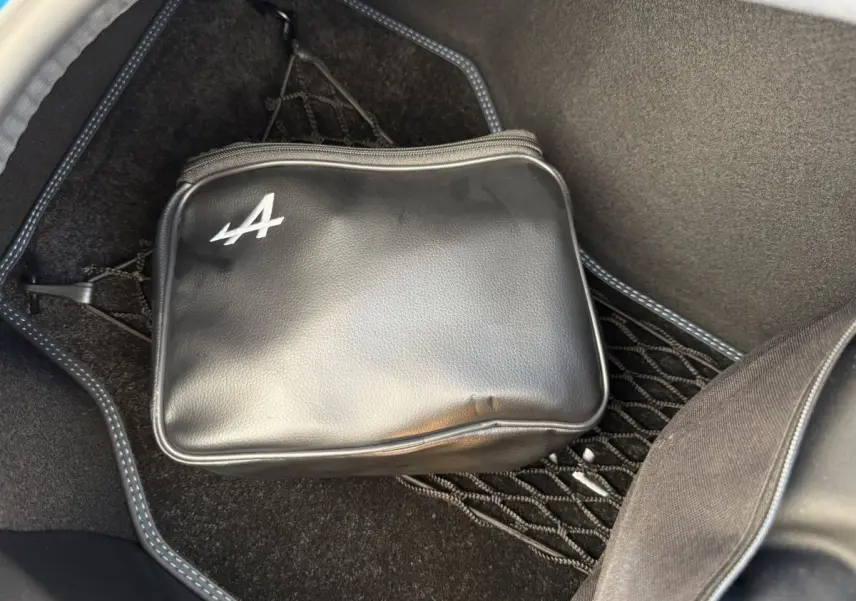 Sacoche noire avec logo Alpine dans le coffre avant d'une Alpine A110 Legende bleu 2019 vue en plongée.