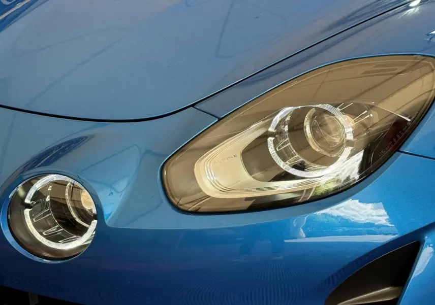 Gros plan sur le phare avant droit et le feu antibrouillard d'une Alpine A110 Légende bleue 2019.