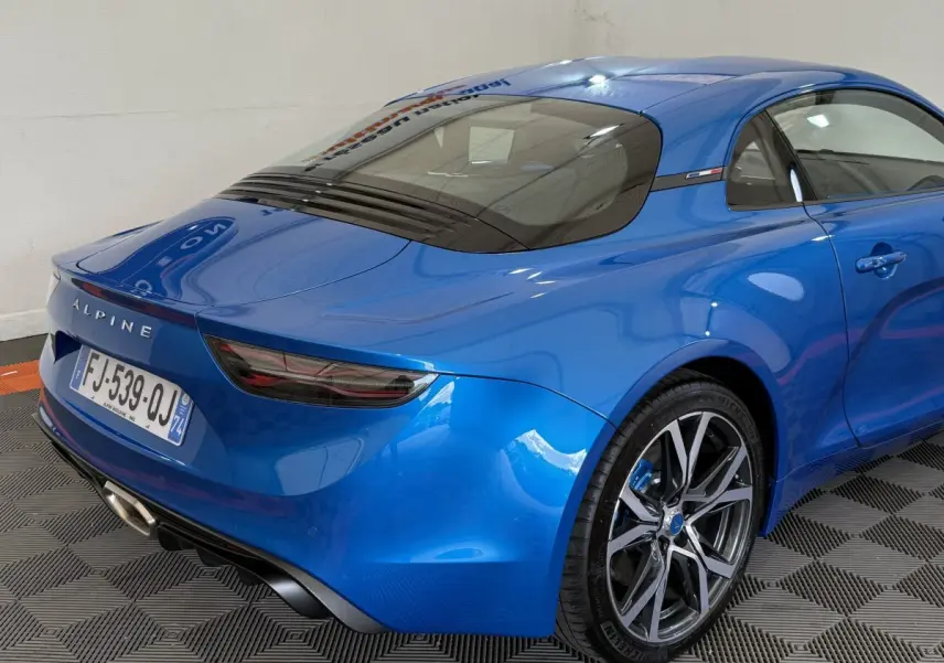 Vue 3/4 arrière droite d'une Alpine A110 Légende bleu brillant avec feux arrière LED et jantes alliage distinctives.