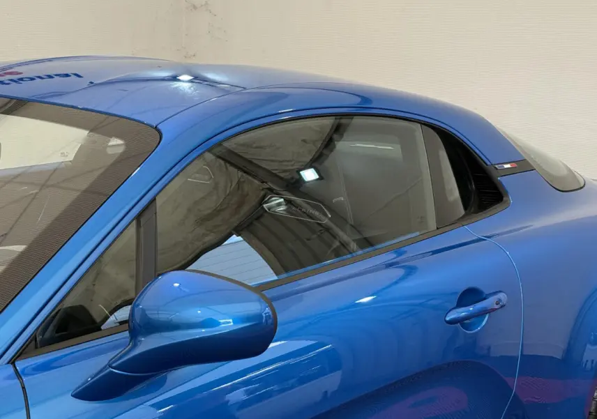 Vue latérale droite d'une Alpine A110 Legende 2019 bleu brillant avec rétroviseur et poignée de porte visibles.
