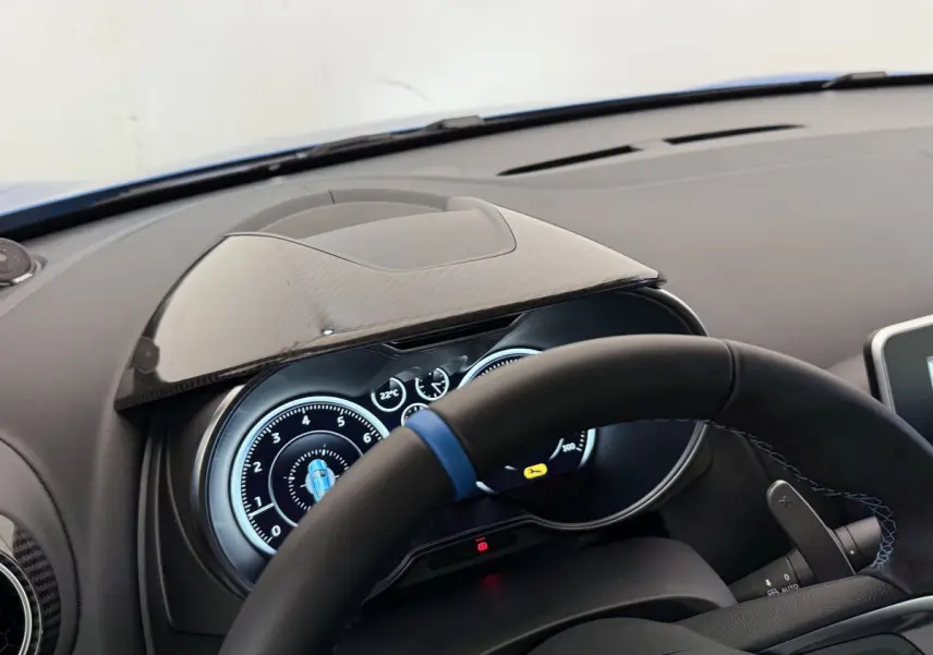 Tableau de bord et compteurs numériques de l'Alpine A110 Legende 2019 vus côté conducteur, volant cuir noir avec bande bleue.