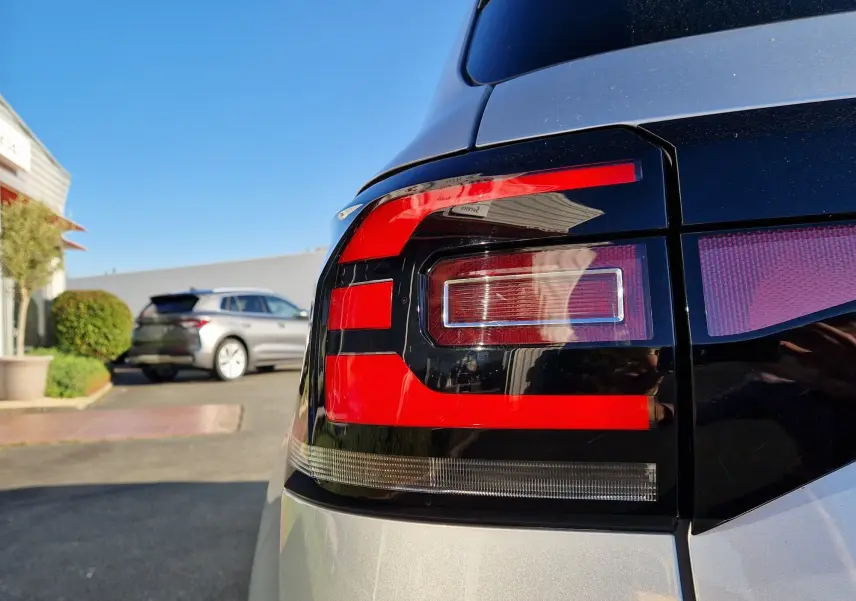 Gros plan sur le feu arrière droit argent métallisé du Volkswagen T-Cross 2019, avec un autre véhicule en arrière-plan.