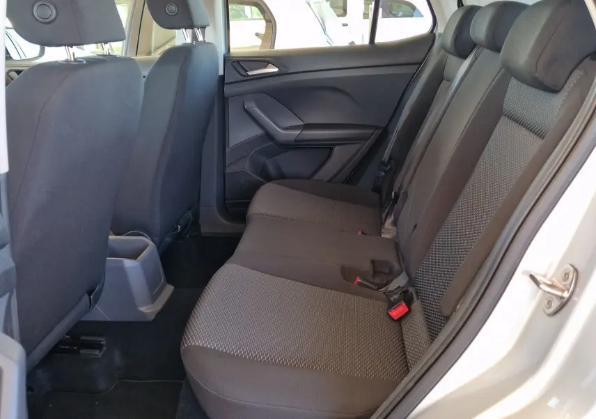 Intérieur arrière du Volkswagen T-Cross argent métal 2019, vue côté gauche avec sièges tissu gris et ceinture de sécurité rouge.