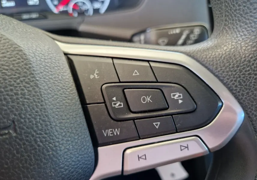 Gros plan sur les commandes multifonctions à droite du volant en cuir noir du Volkswagen T-Cross argent métal 2019.