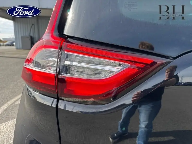 Gros plan sur le feu arrière droit du Renault Grand Scenic noir étoilé de 2017, avec reflet sur la carrosserie.