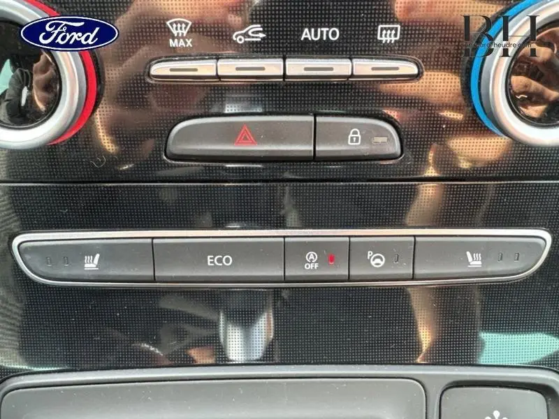 Gros plan sur la console centrale noire étoilé du Renault Grand Scenic 2017, avec boutons de chauffage et mode ECO visibles.