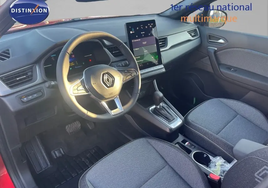 Vue intérieure avant droite du Renault Captur E-Tech hybride 2025, avec tableau de bord numérique et sellerie tissu gris.