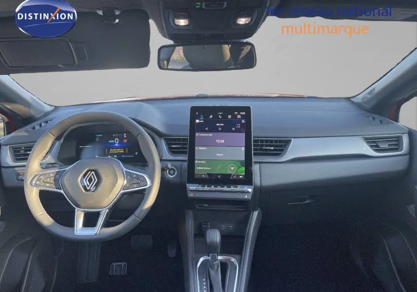 Vue intérieure du tableau de bord du Renault Captur E-Tech hybride 2025 avec écran tactile vertical et volant multifonction noir.