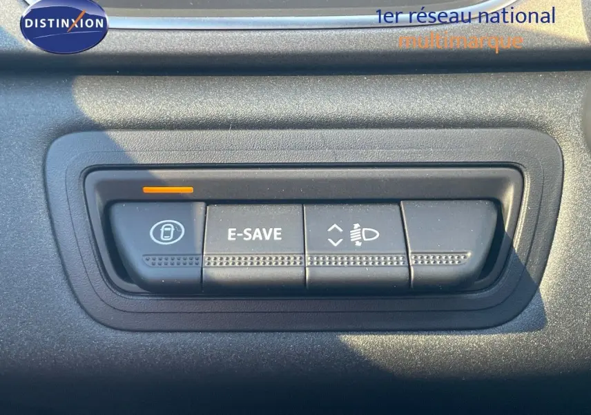 Gros plan sur les boutons de commande E-SAVE et réglage des phares du Renault Captur rouge passion 2025.