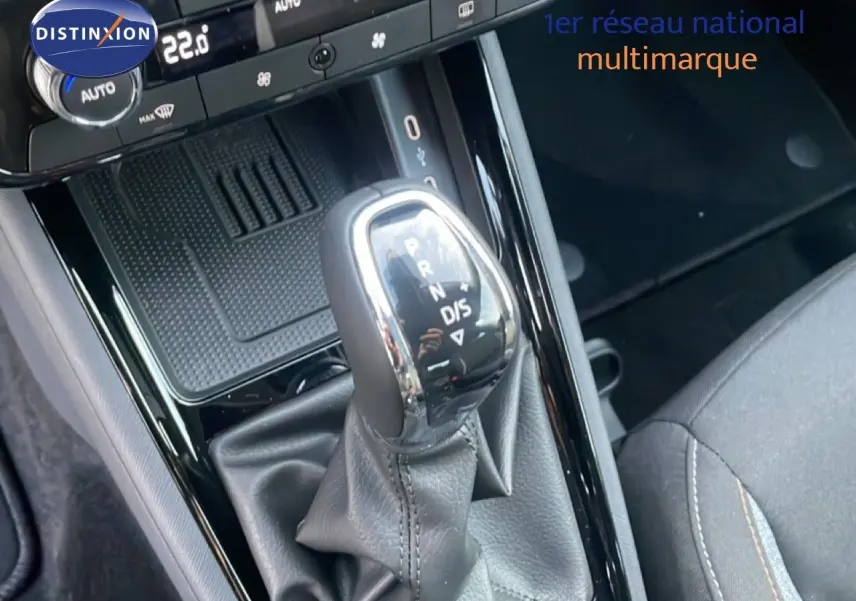 Gros plan sur le levier de vitesse automatique d’un Skoda Kamiq gris argent, intérieur avec sellerie noire.