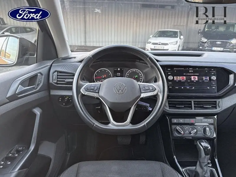 Vue intérieure centrée sur le volant cuir multifonction du Volkswagen T-Cross 2022 avec tableau de bord et écran tactile.