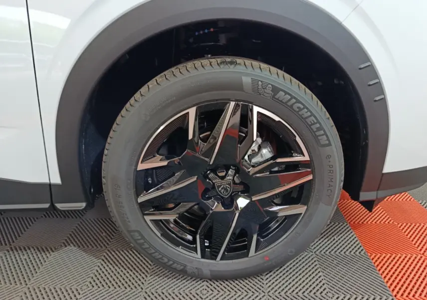 Gros plan sur la roue arrière droite noire et chromée du Peugeot 3008 blanc, avec pneu Michelin visible.