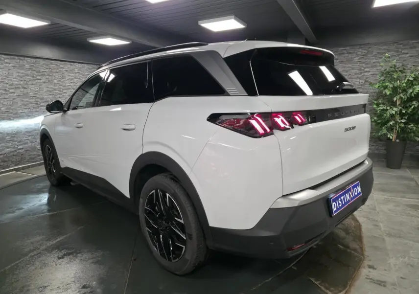 Vue 3/4 arrière droite du Peugeot 5008 blanc avec feux arrière LED à 3 griffes et jantes alliage noires.