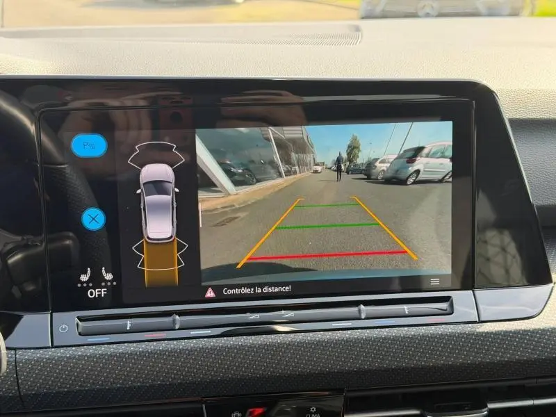Vue de l'écran multimédia affichant la caméra de recul et l'aide au stationnement d'une Volkswagen Golf 2024.