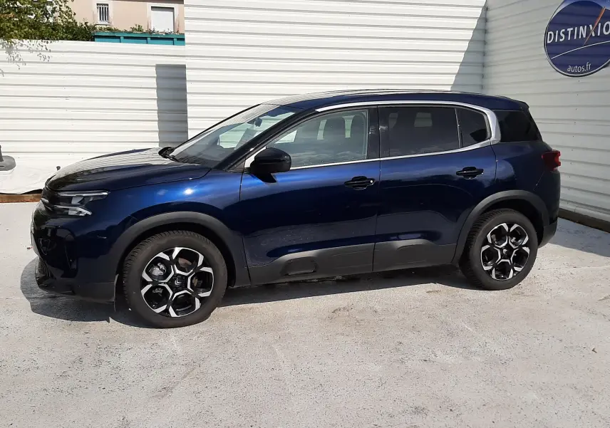 Vue de profil côté gauche d'un Citroën C5 Aircross bleu éclipse 2025 avec jantes bi-ton et toit noir.