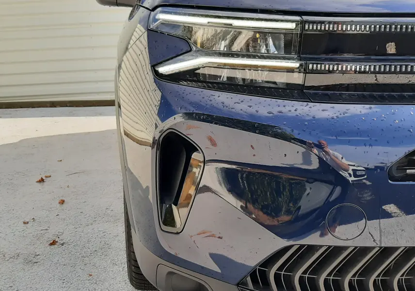 Gros plan sur l'avant gauche du Citroën C5 Aircross bleu éclipse 2025, mettant en valeur les phares LED et la calandre distinctive.
