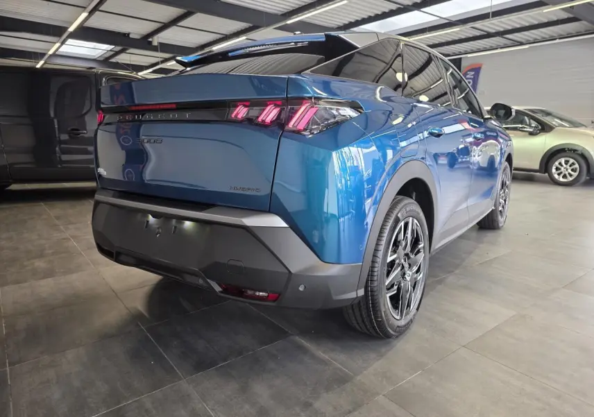 Vue 3/4 arrière droite du Peugeot 3008 hybride bleu métallisé avec feux arrière à LED en forme de griffes et jantes alliage 18 pouces.
