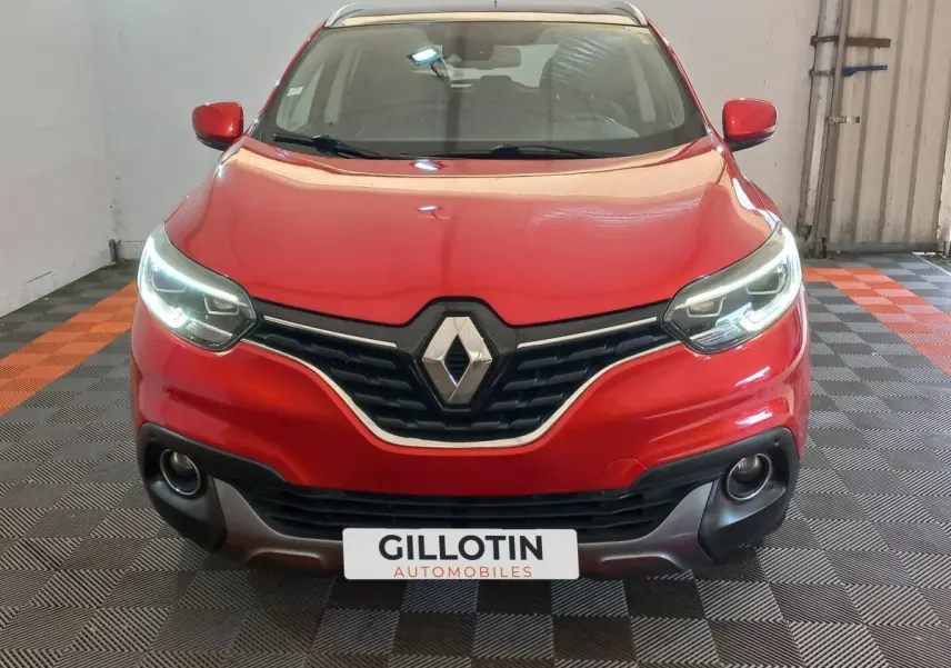 Vue avant d'un Renault Kadjar Intens Energy TCe 130 EDC rouge avec feux LED allumés dans un garage.