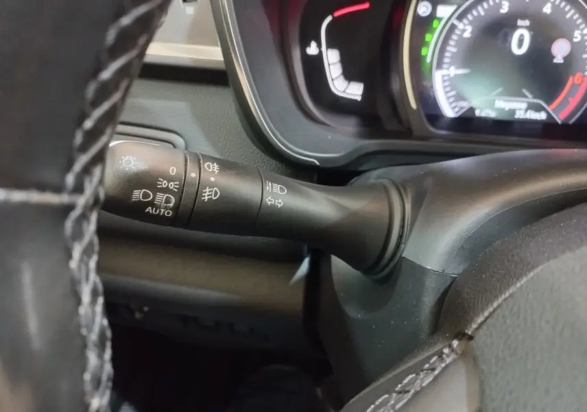 Gros plan sur la manette de commande des phares et clignotants du tableau de bord noir du Renault Kadjar Intens 2018.