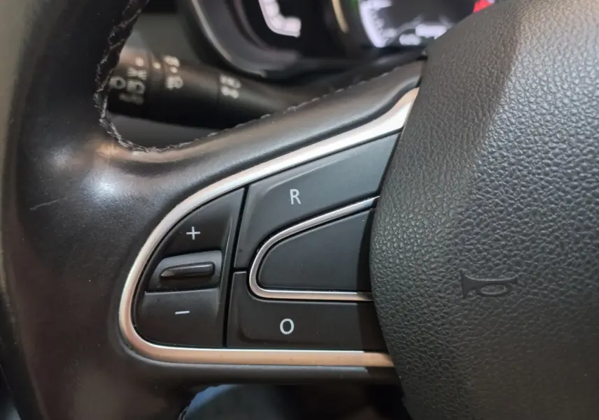 Gros plan sur les commandes de régulateur de vitesse au volant cuir noir du Renault Kadjar Intens 2018.