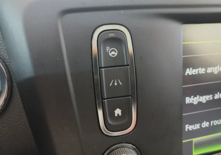 Gros plan sur les boutons de commande d’aide au stationnement et d’alerte de franchissement de ligne dans le tableau de bord Renault Kadjar Intens 2018.