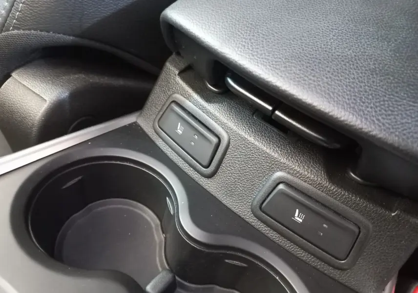 Gros plan sur les commandes de sièges chauffants et porte-gobelets noirs dans l'habitacle du Renault Kadjar Intens 2018.
