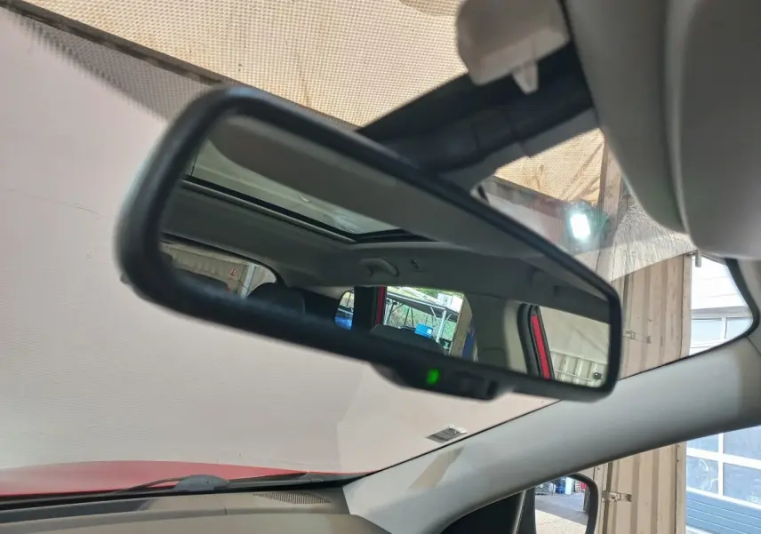 Rétroviseur intérieur d’un Renault Kadjar Intens rouge, avec toit ouvrant et partie de l’habitacle visible en reflet.