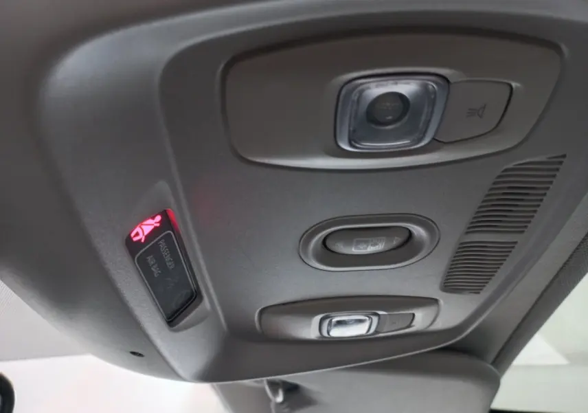 Vue en gros plan du plafonnier gris avec commandes d'éclairage et témoin airbag passager allumé dans un Renault Kadjar.