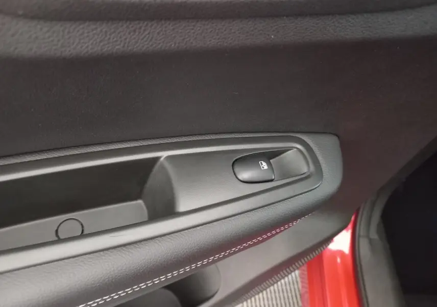 Détail de la commande de verrouillage de porte sur la portière côté conducteur d’un Renault Kadjar rouge.