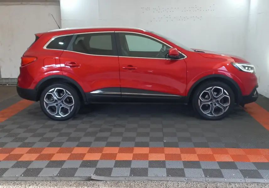 Profil côté gauche d'un Renault Kadjar rouge 2018 avec jantes alliage et détails noirs sur bas de caisse.