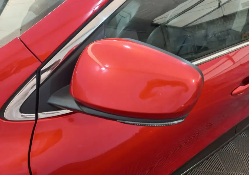 Rétroviseur côté gauche rouge vif du Renault Kadjar Intens Energy TCe 130 EDC, vue rapprochée sur porte et vitre.