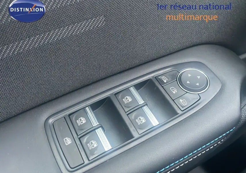 Gros plan sur les commandes des vitres électriques et rétroviseurs du côté gauche d’un Renault Captur rouge passion avec toit noir.