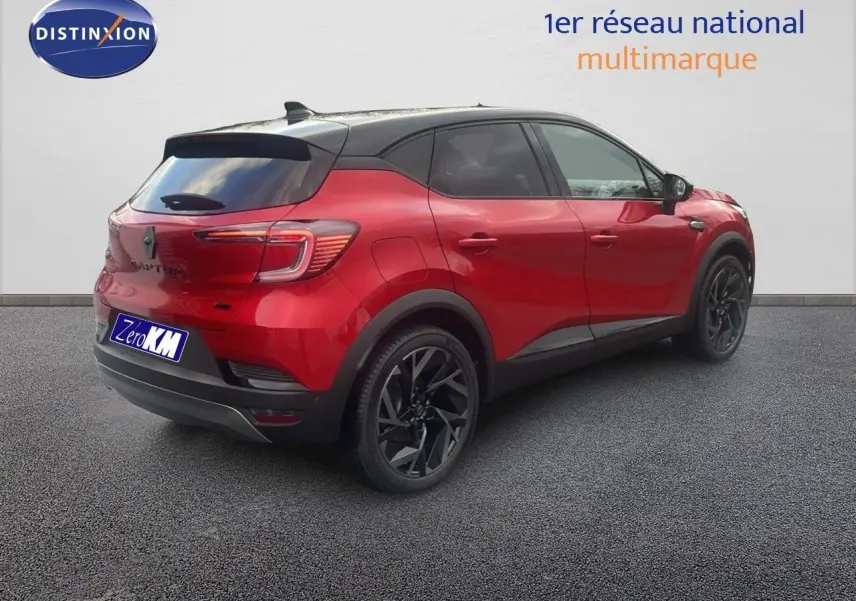Renault Captur E-Tech hybride rouge passion avec toit noir, vue 3/4 arrière côté droit, jantes noires distinctives.