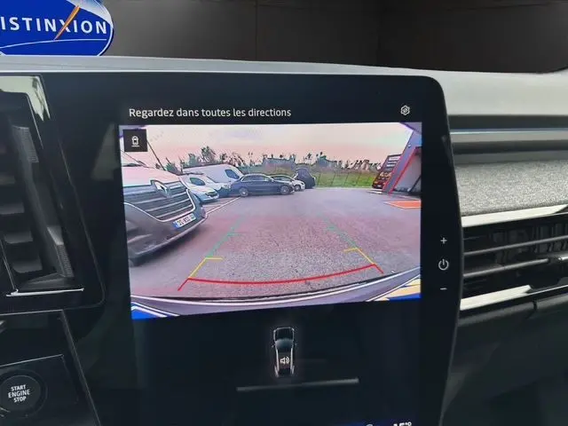 Écran intérieur affichant la caméra de recul du Renault Austral PH2 Techno hybride, vue arrière avec parking et véhicules environnants.
